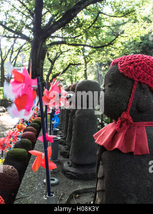 Jizo statue, con offerte di giocattoli, il tempio di Zojo-ji, Minato, Tokyo, Giappone Foto Stock