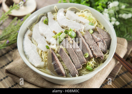 Ciotola cinese di immotivata noodle con carne di maiale anf sul tavolo nel ristorante Foto Stock