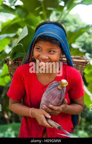 Una ragazza Chakma nell'area Rangamati in Bangladesh raccoglie banana fiori che verrà utilizzato per effettuare il curry, Bangladesh Asia Foto Stock