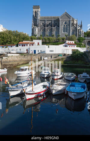 Piccolo porto con le tradizionali barche da pesca e Eglise Sainte Eugenie a Biarritz, Pirenei Atlantiques, Aquitania, in Francia, in Europa Foto Stock