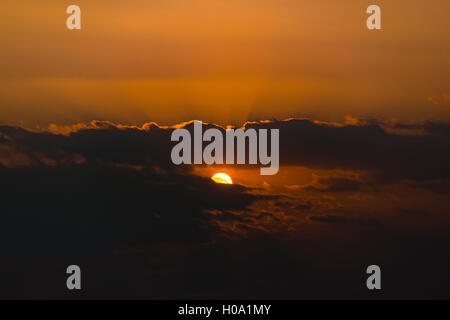 Tramonto, il sole che splende attraverso le nuvole scure, Mandalay Regione, Myanmar Foto Stock