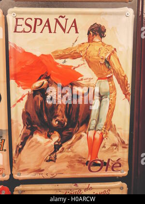 Poster Vintage della corrida in Spagna con bull passando al di sotto del mantello rosso di elegante abile torero indossando il costume tradizionale Foto Stock