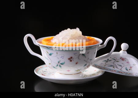 Dolci misti succo di frutta in tazza cinese su sfondo nero Foto Stock