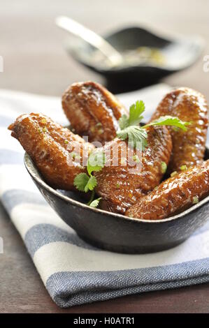 Alette di pollo fritte su nero ciotola in ristorante Foto Stock