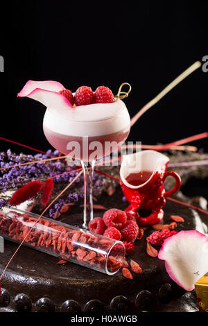 Bicchiere di cocktail strawbery sulla torta al cioccolato in sfondo nero Foto Stock