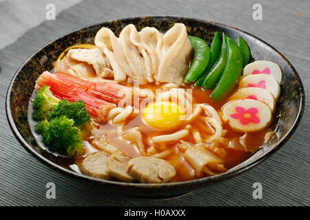 Udon noodle in stile giapponese con tempura, maiale, pesce, pasta, uovo e broccoli Foto Stock