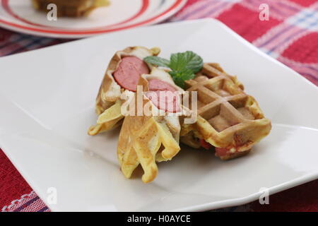 Il francese di hot dog con salsicce e foglia di menta sulla piastra bianca Foto Stock