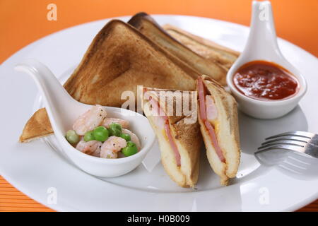 Il francese di hot dog con gamberi e fagioli verdi sulla piastra bianca Foto Stock