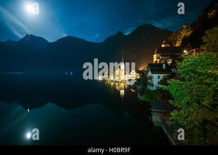 Hallstatt Austria notte foto. Hallstatt Cityscape e la luna riflessi del lago. Foto Stock