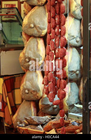 Differenti varietà di salumi appesi a un negozio di gastronomia Foto Stock