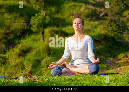Giovane sportivo da donna adatta a praticare lo yoga Lotus pongono oudoors Foto Stock