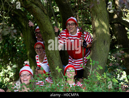 Dragon Boat racing, i membri di un team che indossa dove la Wally fancy dress nascondere in alberi. Foto Stock