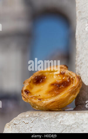 Tradizionale portoghese crostata di uovo pastoso dessert torta Pasteis de nata su sfondo attrazioni di Lisbona, Portogallo. Foto Stock