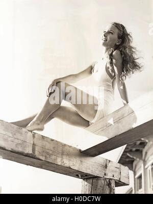 La donna a prendere il sole su un molo Foto Stock