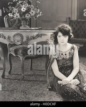 Triste donna seduta sul pavimento Foto Stock