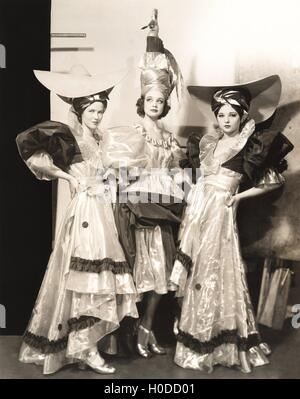 Tre danzatori in abiti lunghi e grandi cappelli Foto Stock