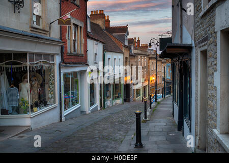 Tramonto su Catherine Hill una strada di ciottoli di edifici storici a Frome in Somerset Foto Stock