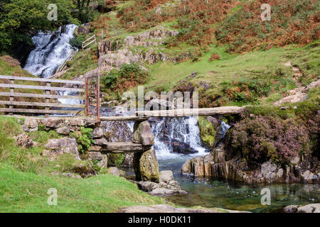 Antica pietra battaglio passerella sul percorso attraversando Afon Cwm Llan river sotto la cascata nel Parco Nazionale di Snowdonia. Wales, Regno Unito Foto Stock