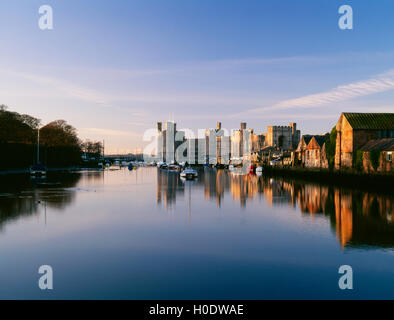 Caernarfon Castle e la banchina di ardesia sul fiume Seiont, Caernarfon, Gwynedd, Galles del Nord, Regno Unito; sera alta marea Foto Stock