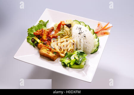 Profumato pesce fritto fila, Kung Pao pollo con verdura sulla piastra bianca in sfondo bianco Foto Stock