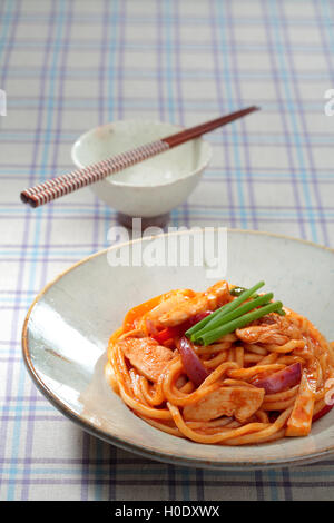 Chicken fried noodles sul classico cinese ciotola con bacchette sul tavolo Foto Stock