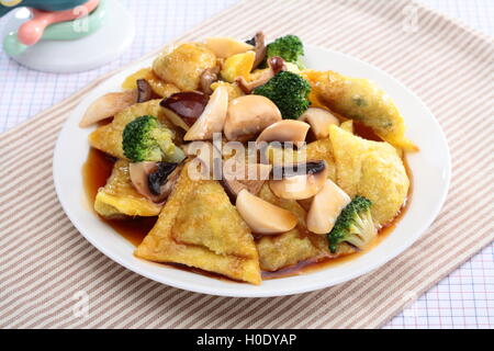 Fried Beoseottang può ravioli ai funghi e broccoli sulla piastra bianca Foto Stock