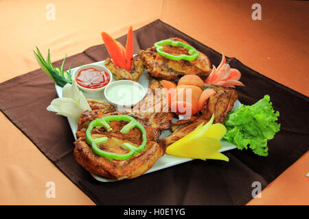 Delizioso fritto di pollo disossate con peperoncino, lattuga e salsa Foto Stock