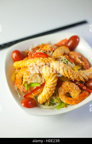 Fritti insalata di calamari con pomodori e verdure sul recipiente bianco Foto Stock