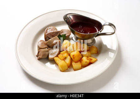 Linguetta di renne con patate fritte e salsa di pomodoro sulla piastra bianca nel ristorante Foto Stock