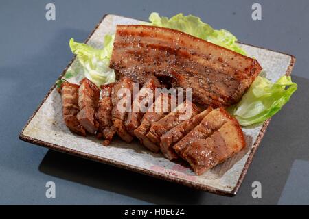 La piastra di piatti Hakka pepe pancetta con lattuga su sfondo grigio Foto Stock