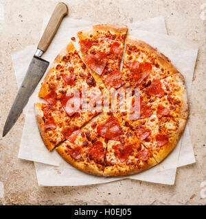 Forma di cuore fette di salsiccia per pizza Pizza su pietra Travertino sfondo Foto Stock