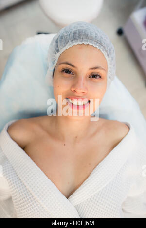 Bella donna paziente sorriso sdraiato sul letto in camera operatoria ospedale Foto Stock