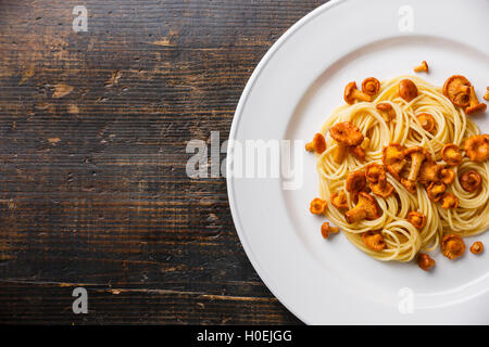 Pasta spaghetti con bosco selvatico funghi chanterelle sulla piastra bianca e copia di sfondo spazio Foto Stock
