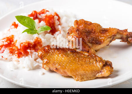 Buffalo ali di pollo con riso e salsa di pomodoro sulla piastra bianca Foto Stock