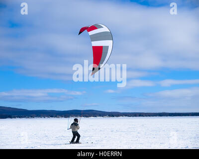 Gli uomini lo sci Snowkiting su un lago ghiacciato Foto Stock