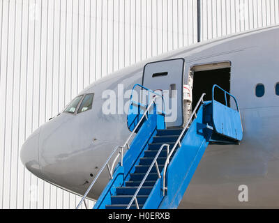 Grande aereo passeggeri parcheggiata vicino hangar Foto Stock