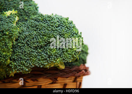 Close up sui broccoli freschi solated nel cesto su legno e sfondo bianco Foto Stock
