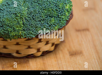 Broccoli freschi solated nel cesto su sfondo di legno Foto Stock