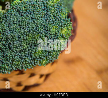 Close up sui broccoli freschi solated nel cesto su sfondo di legno Foto Stock