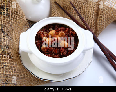 Rosso di riso appiccicoso con lotus bean sulla vaschetta bianca in ristorante Foto Stock