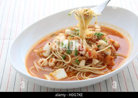 Pasta a base di noodle con frutti di mare, capesante e calamari in bianco ciotola sul tavolo di legno Foto Stock