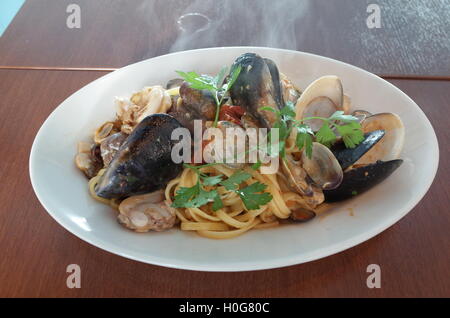 Pasta a base di noodle di cozze e vongole con erbe su piastra bianca Foto Stock