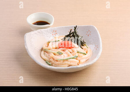 A base di noodle giapponesi di Hakata Mentai Mayo Udon con salsa soyal sul tavolo di legno Foto Stock