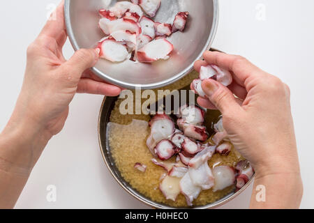 La preparazione di fresco affettato octopus per cucinare il riso in cucina con le mani Foto Stock