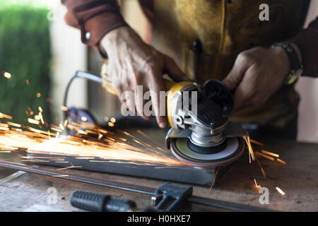 Arredamento personalizzato lavoratore grind giunzioni di saldatura su acciaio. Foto Stock