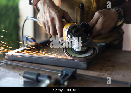 Arredamento personalizzato lavoratore grind giunzioni di saldatura su acciaio. Foto Stock