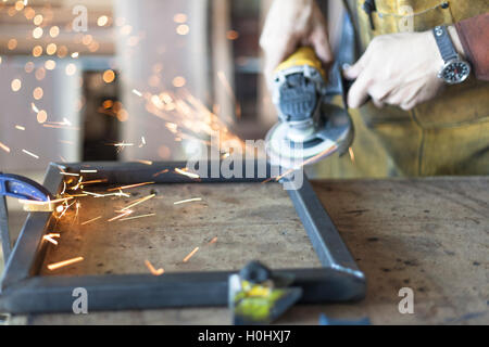 Arredamento personalizzato lavoratore grind giunzioni di saldatura su acciaio. Foto Stock