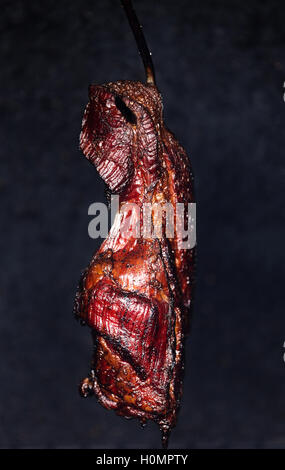 Il fumo appeso al collo di maiale in un modo tradizionale in casa smokehouse Repubblica ceca. molto gustosi piatti a base di carne condita con sale e gar Foto Stock