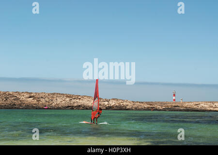 Fuerteventura Isole Canarie: un windsurf con vista di El Faro Toston praticare nella piccola baia di Caleta de la Aduana, Oceano Atlantico Foto Stock