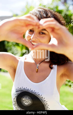 Ragazza messa a forma di cuore con le mani Foto Stock